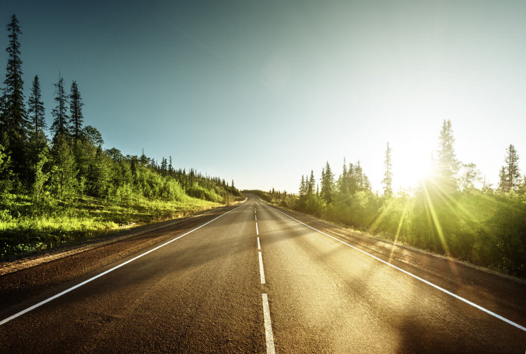 perspective image of a two way road with sun shining