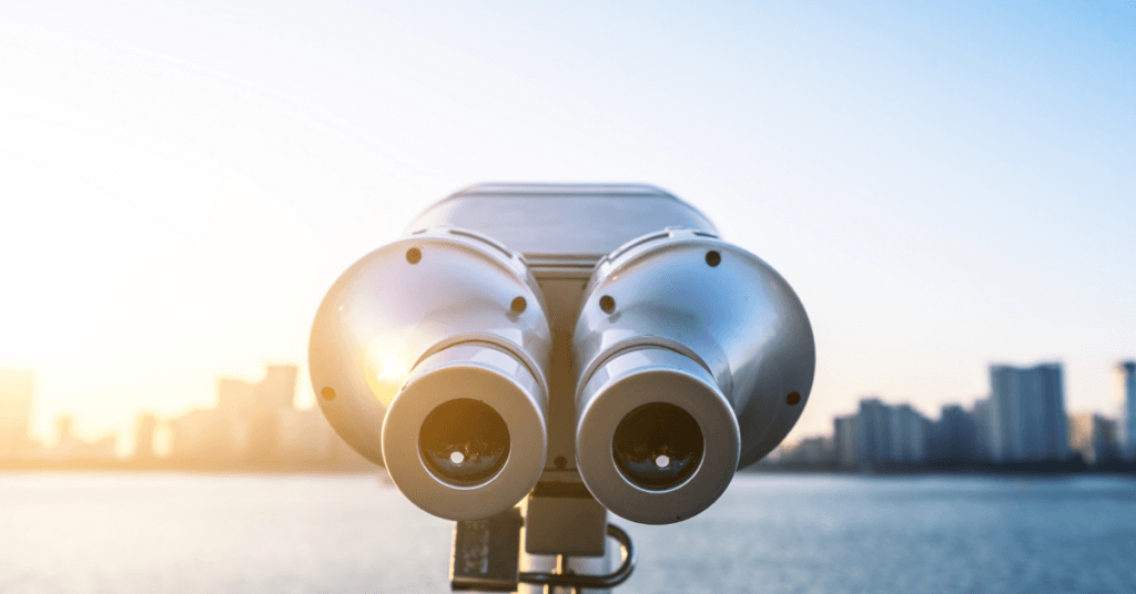 image of a binocular lens looking out towards a city scape